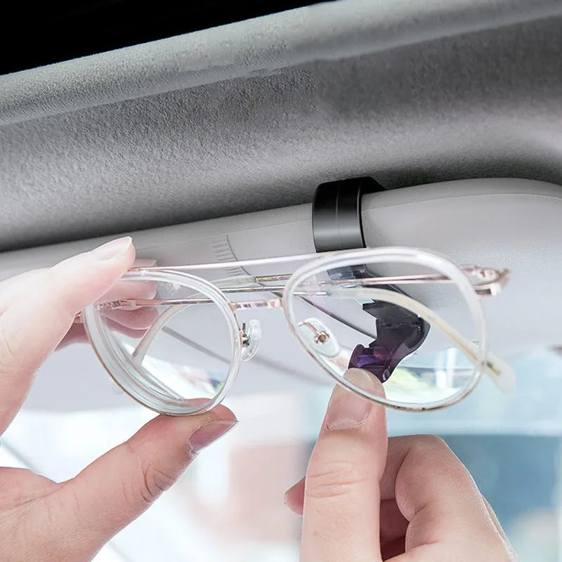 Black plastic multifunctional clip for car sunshade holding sunglasses and cards.