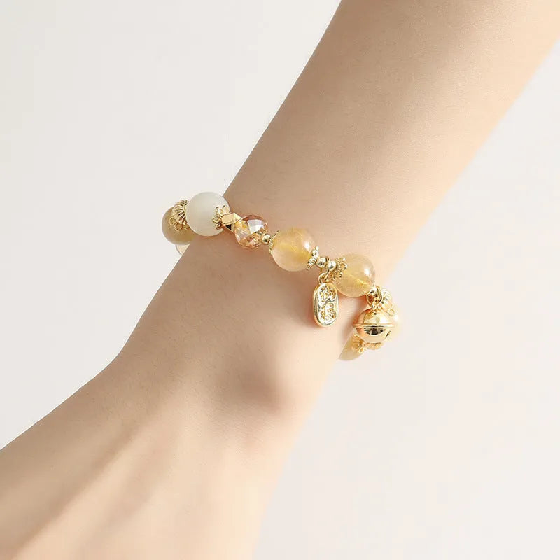 Gold electroplated adjustable bracelet with lucky fortune rutilated quartz crystal beads in a Korean style.