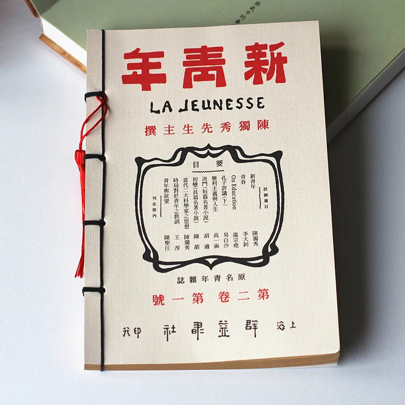 A5 antique wire-bound notebook with glossy embossed cover featuring a retro painting design, shown open.