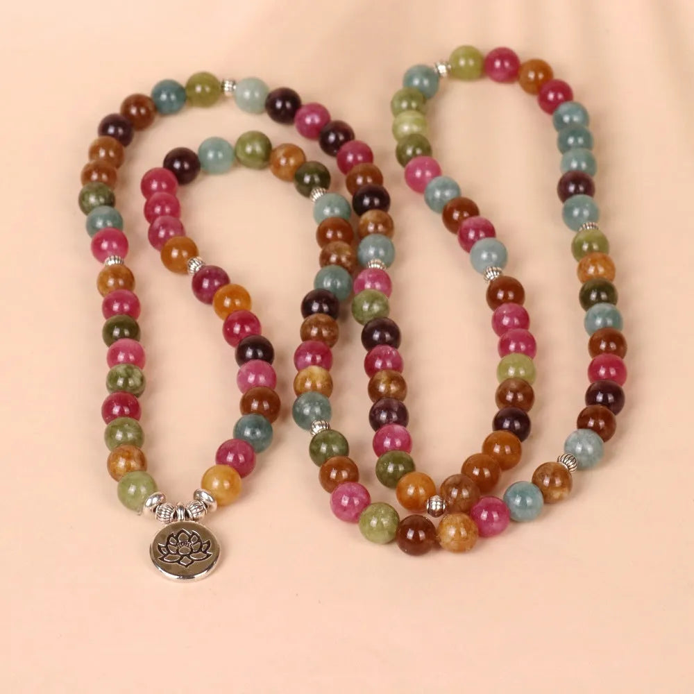 Close-up of a multi-layer beaded bracelet with 108 beads and a hanging lotus charm, made from alloy and tourmaline-coloured material.