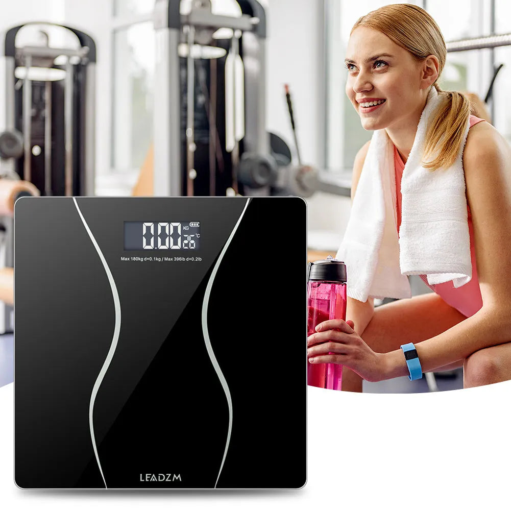 Black electronic bathroom scale on a floor, showing digital display and low-profile platform design.