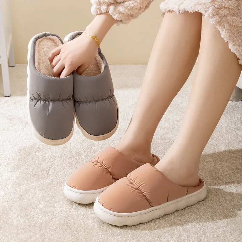 Blue down cotton slippers with artificial leather upper, thick rubber sole, and plush lining shown on a wooden floor.