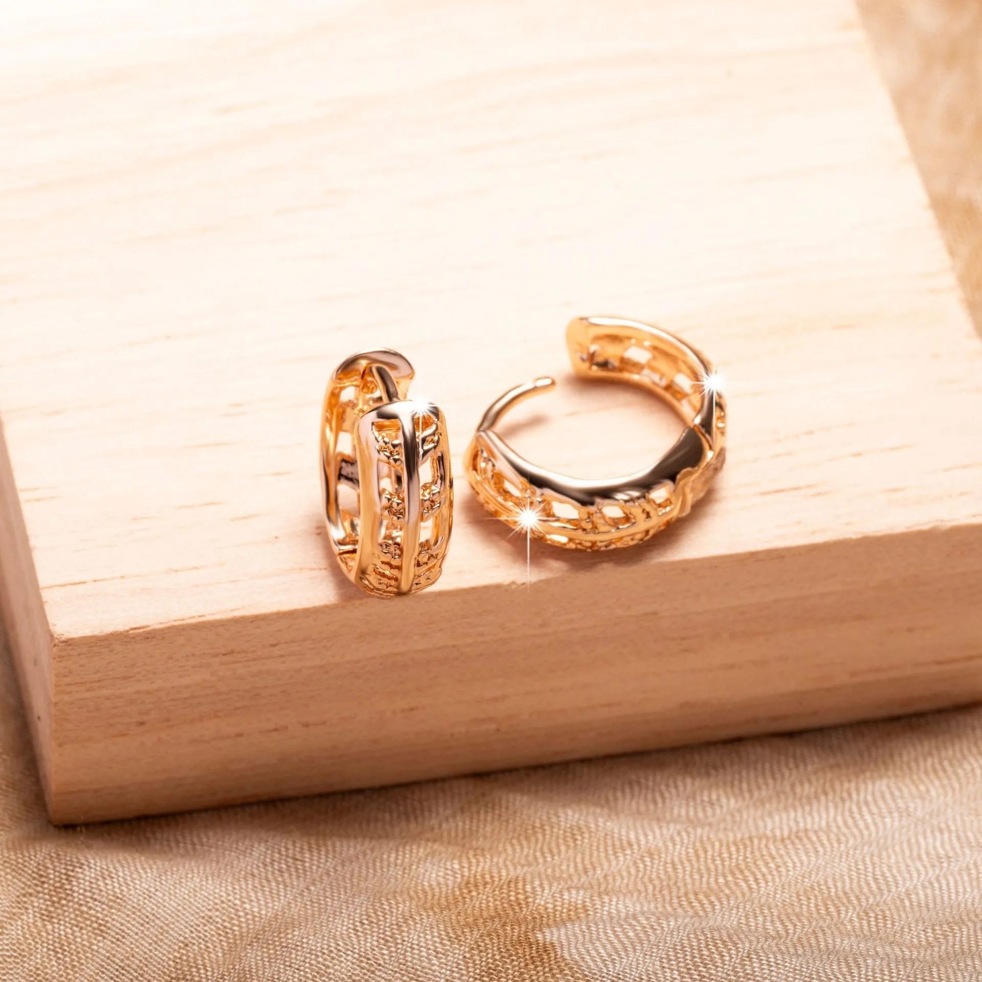 Rose gold hollowed out heart and leaf shaped copper earrings on a white background.
