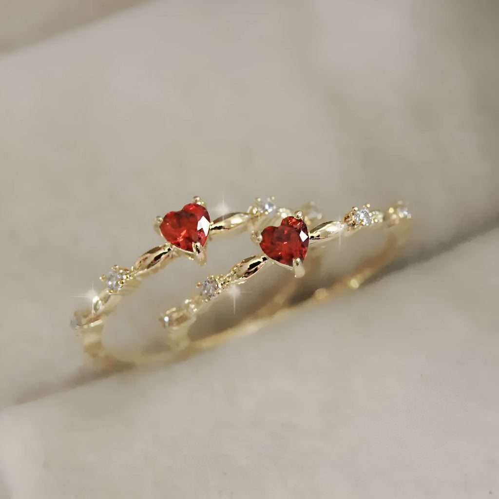 Gold or silver tone peach heart fashion ring with a zircon stone on a model finger.