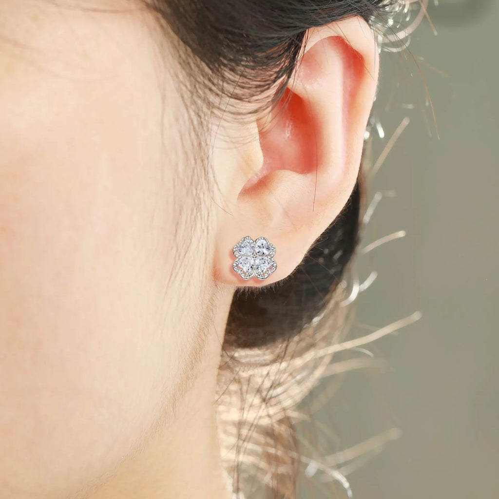 Close-up of women's heart-shaped 925 silver earrings with four-leaf clover zircon inlay, white gold colour finish.