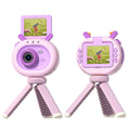 Purple children's digital camera with flip screen, silicone case, and lanyard on a table