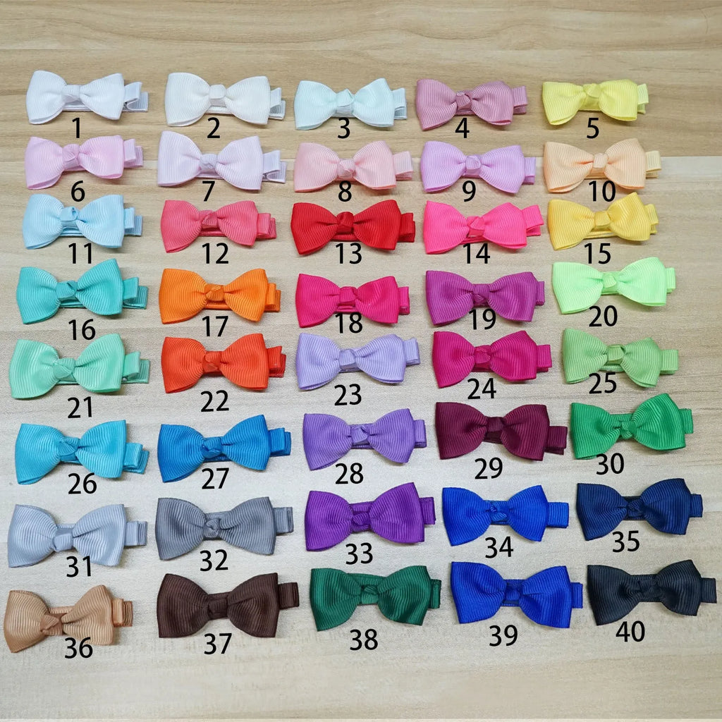 Set of pastel-coloured baby hair clips and bows arranged in rows, showing variety of colours.