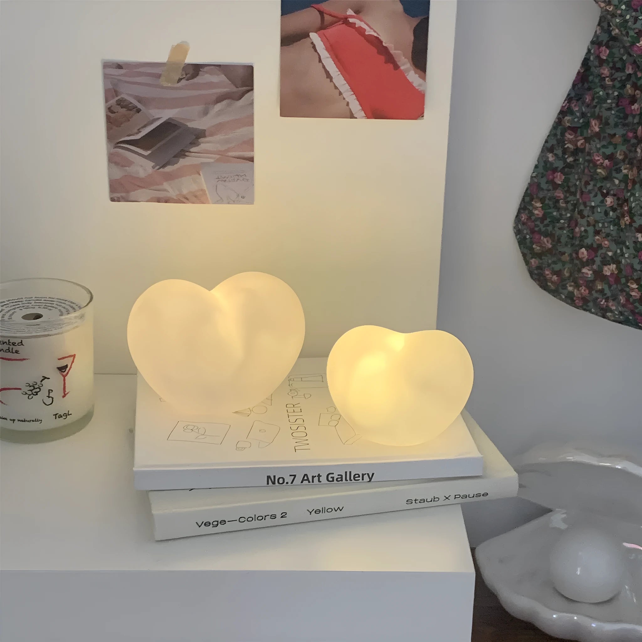 White and pink vinyl love-shaped atmosphere lamps in two sizes on a shelf.