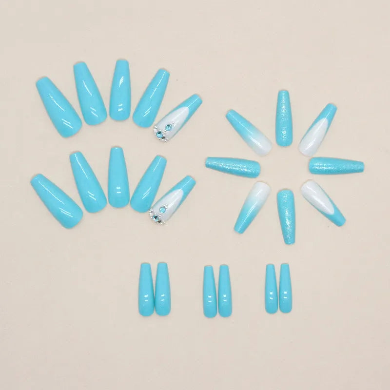 Solid blue long ballet shaped false nail art patches with a bottle of adhesive glue on a white background.