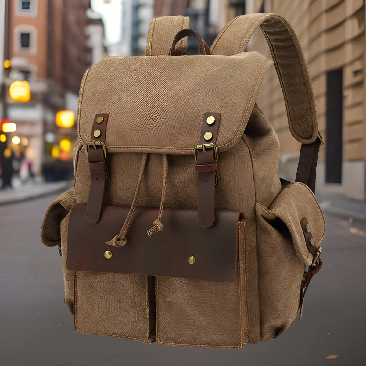 Retro canvas backpack in military green with antique bronze hardware, shown next to a 16-inch laptop.