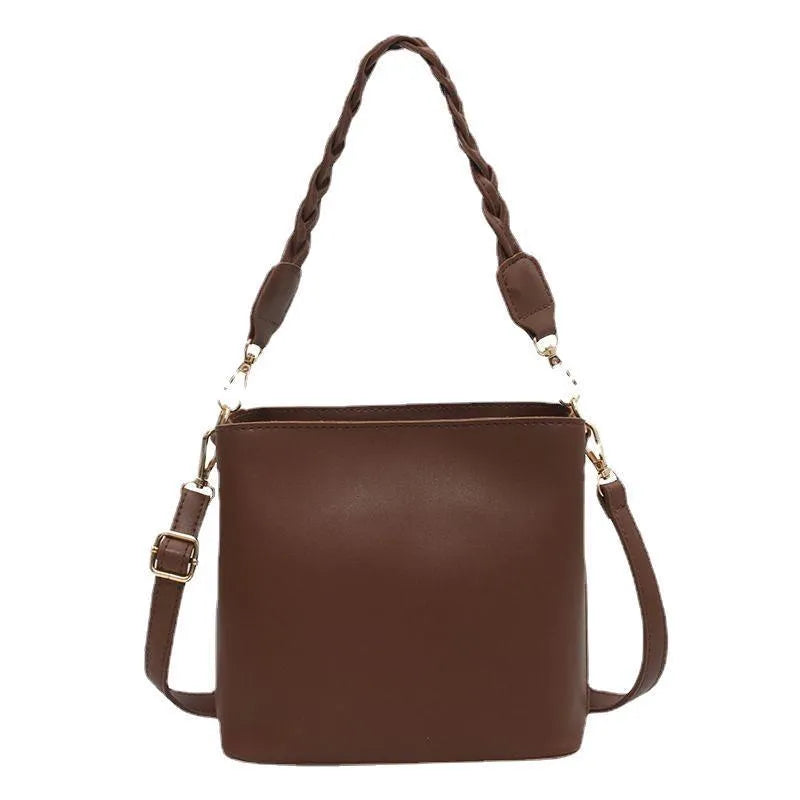Khaki PU woven one-shoulder crossbody bucket bag with retro design on a mannequin