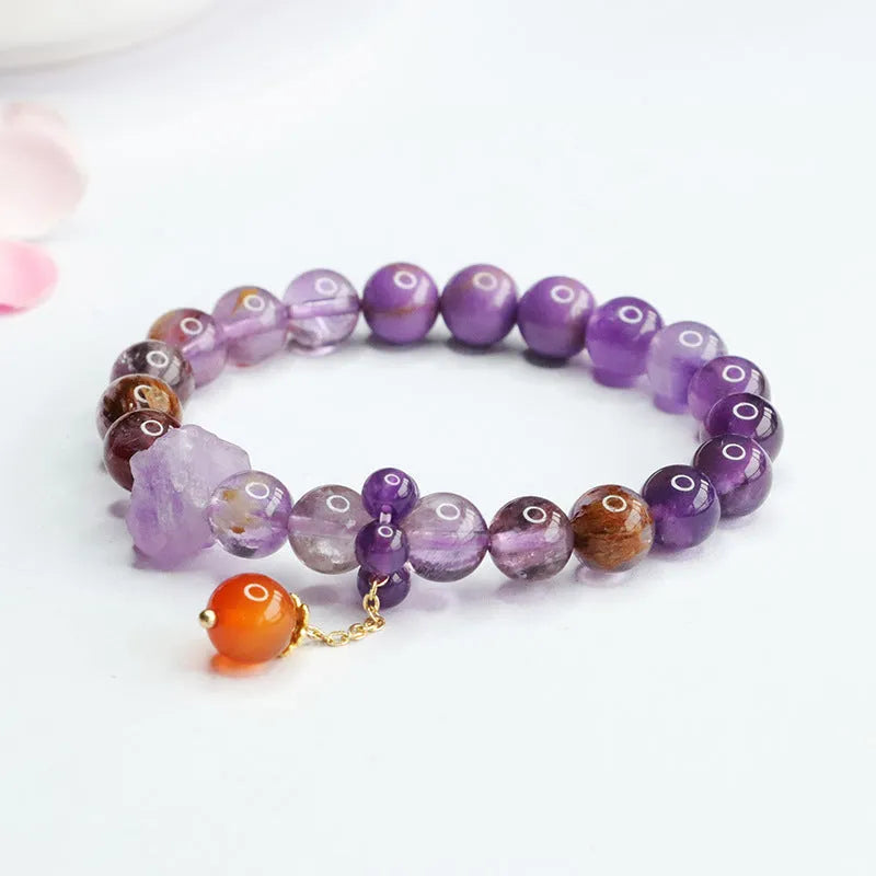 Natural nine purple amethyst and red agate multi-treasure crystal bracelet on wrist.