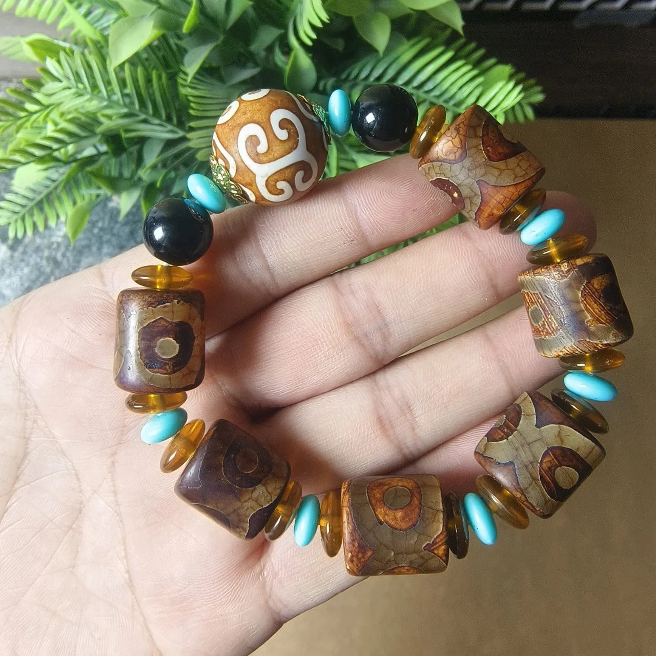 Distressed agate bracelet with traditional Tibetan dzi beads including three-eye and Nine Eyes designs.