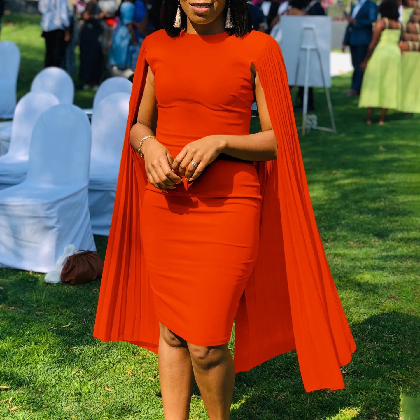 Pleated shawl style evening gown with round neck and long sleeves in formal setting