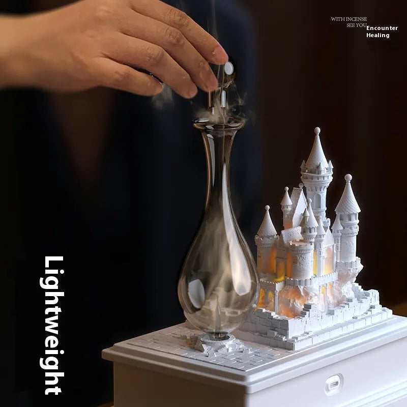 White medieval castle aromatherapy machine with charging cable and essential oil bottle