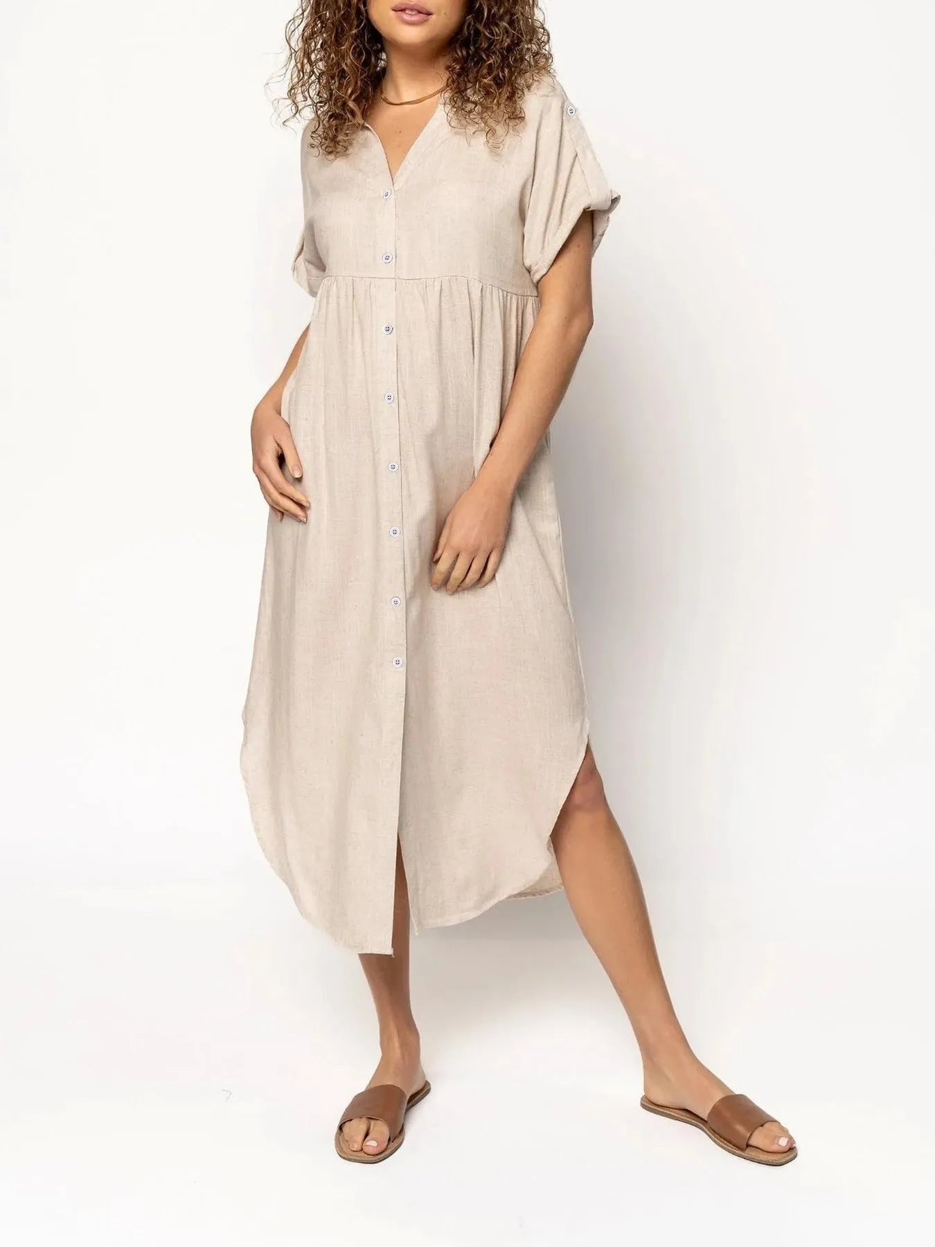 A loose-fitting, solid-colour mid-length casual dress with a front button closure and regular sleeves.