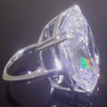 Simple inlaid white square diamond alloy ring for women in white gold colour on a grey background.