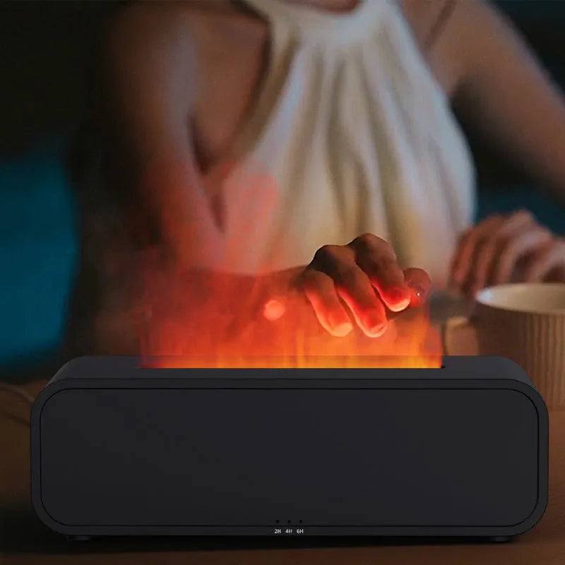 Black aroma diffuser with colour-changing flame light effect and remote control on a table.
