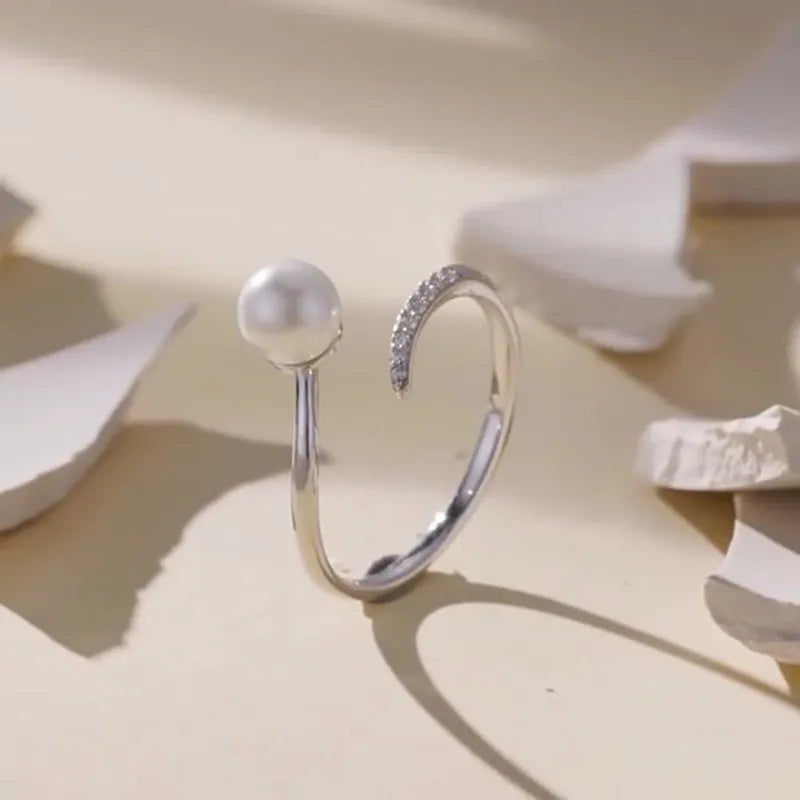 Silver adjustable ring with natural pearl centrepiece showing open loop design