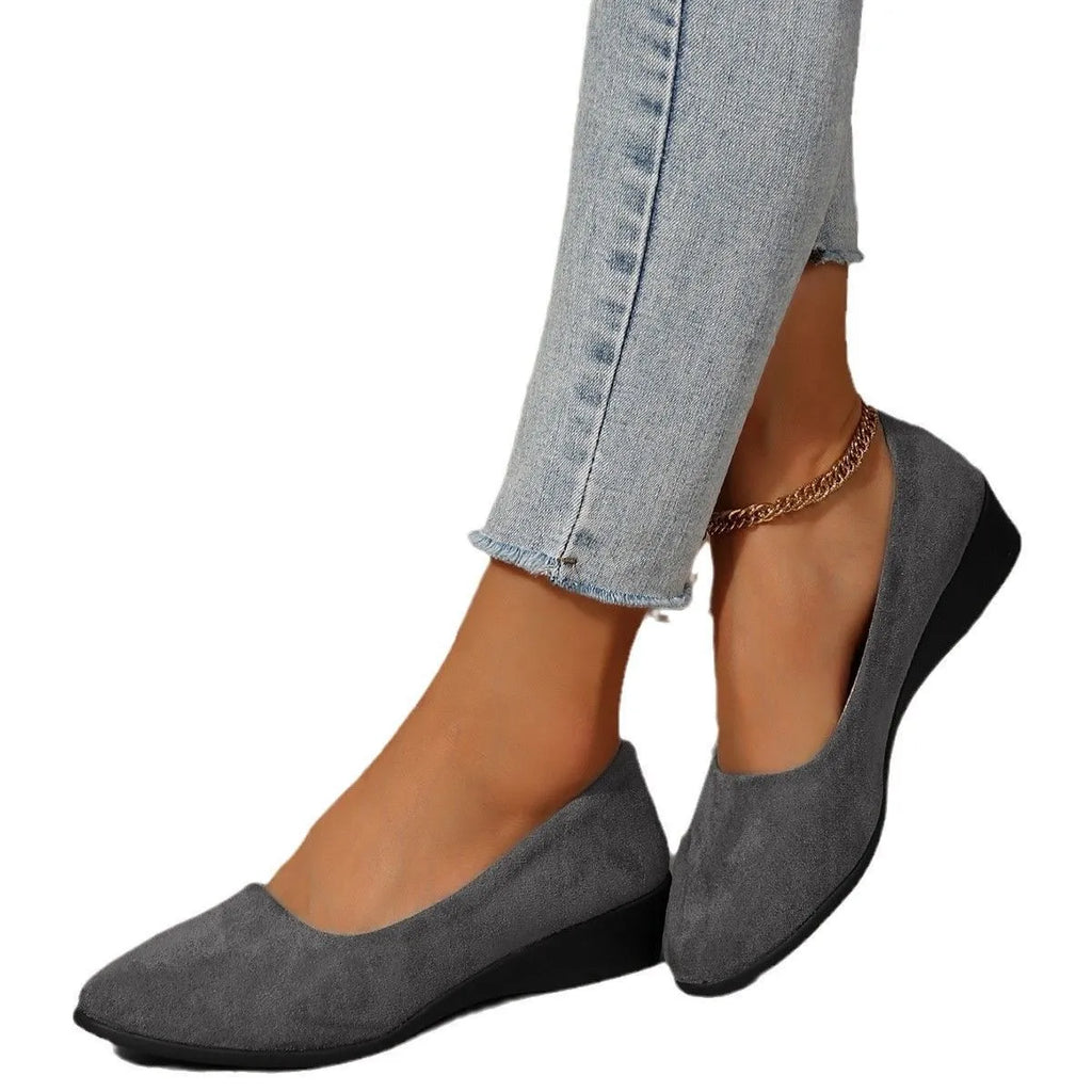 Women's black suede wedge pumps with pointed toe and low rubber sole.
