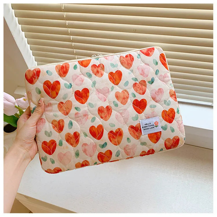 Printed cloth laptop bag for women shown in floral and heart patterns, available in small, medium, and large sizes.