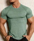Man wearing a tight-fitting green casual short-sleeve t-shirt with a round neck.