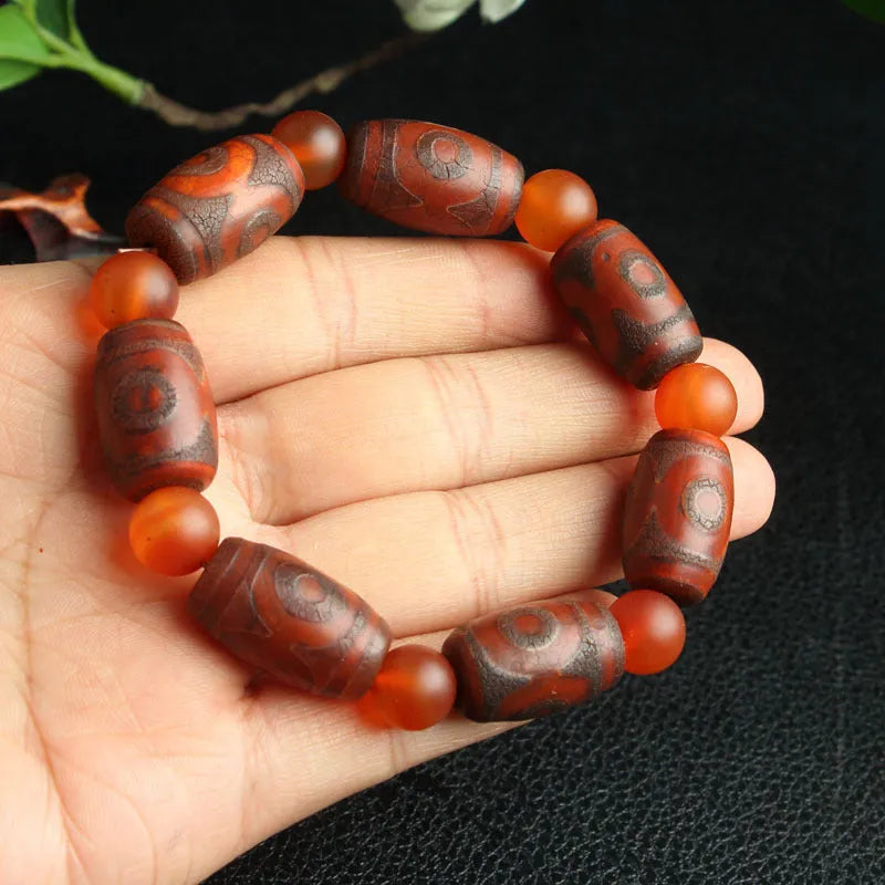Distressed agate bracelet with traditional Tibetan dzi beads including three-eye and Nine Eyes designs.