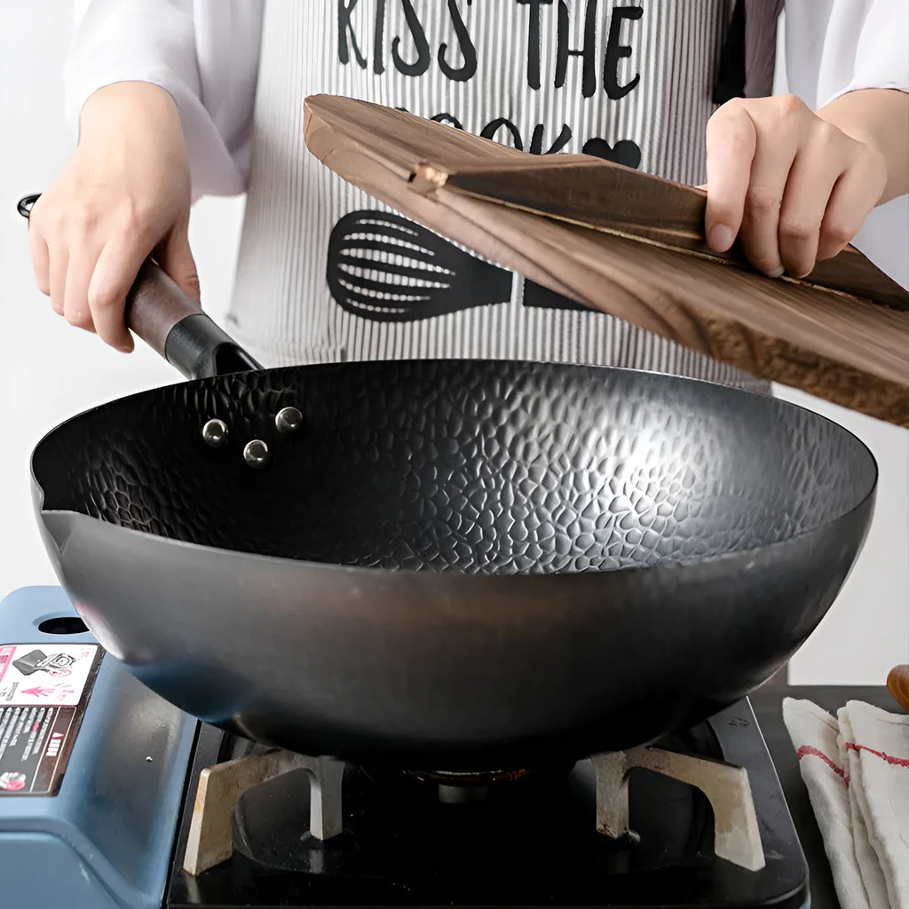 Traditional black iron wok with wooden handle measuring 32cm in diameter