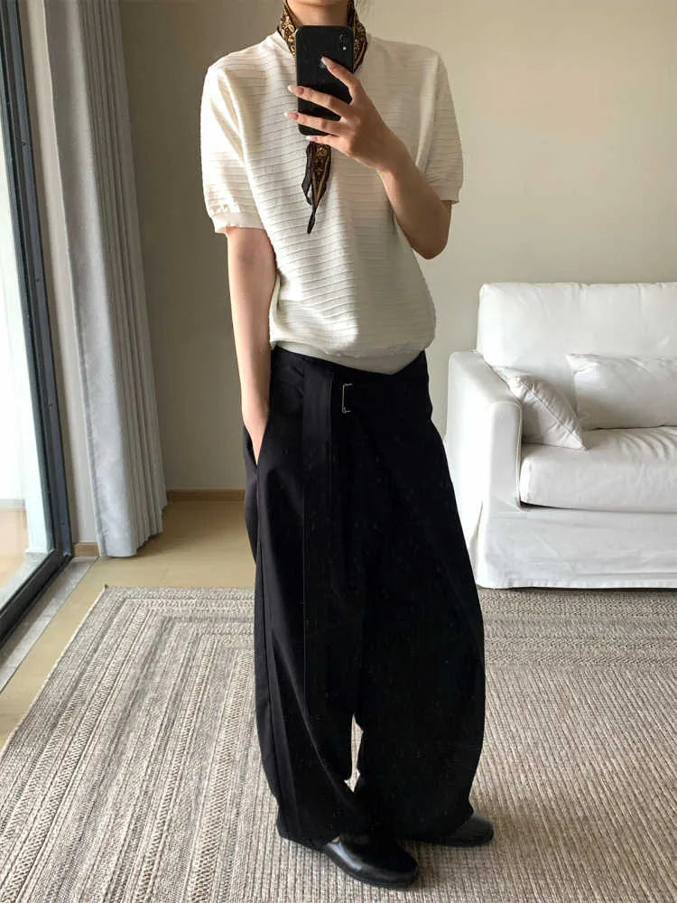 Black straight-leg trousers with a single front pleat and adjustable waistband on a hanger.
