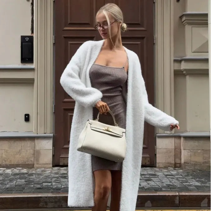 White thick knitted women's cardigan jacket with long sleeves and extended length.