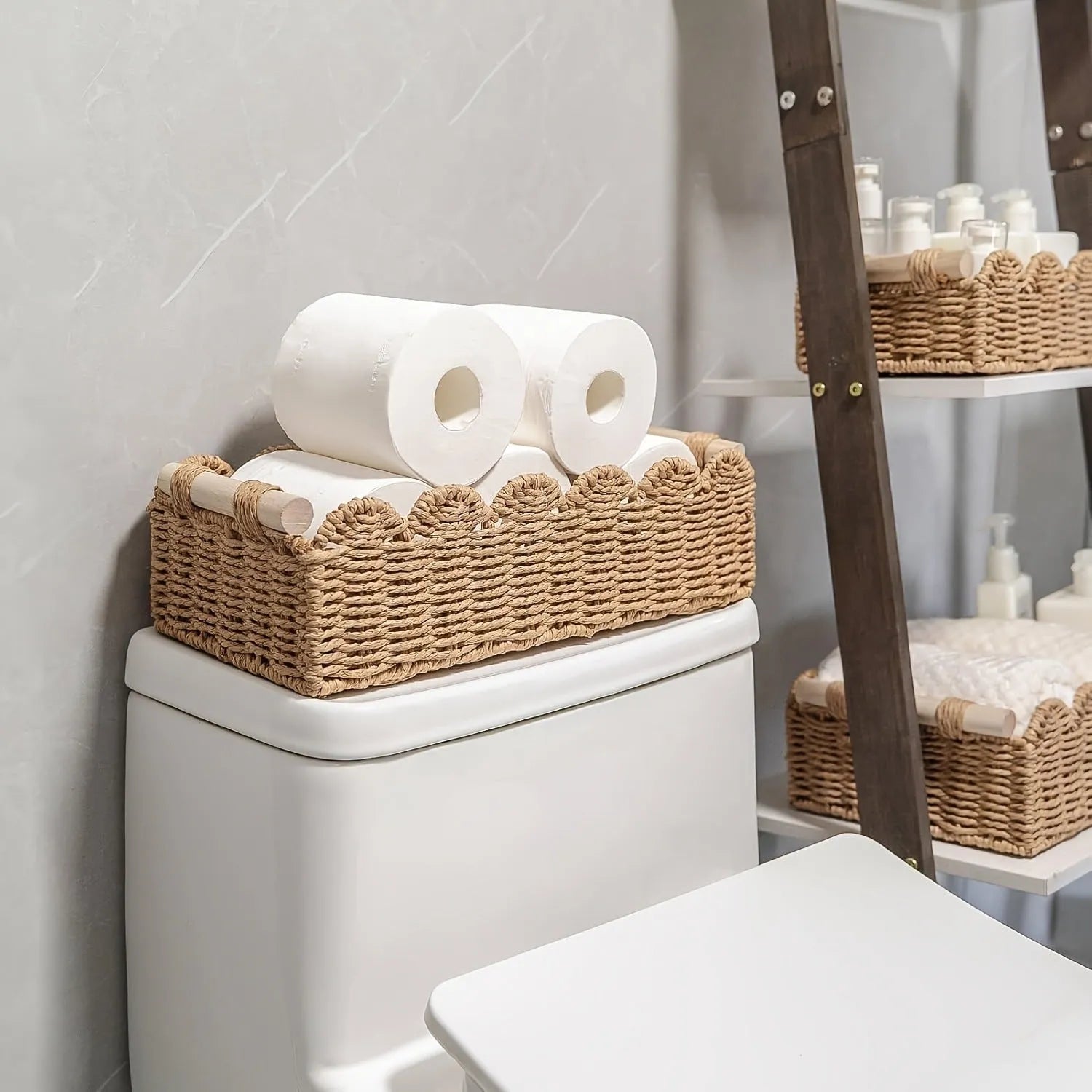Woven paper storage basket in khaki colour on a wooden desk holding remote controls and pens.