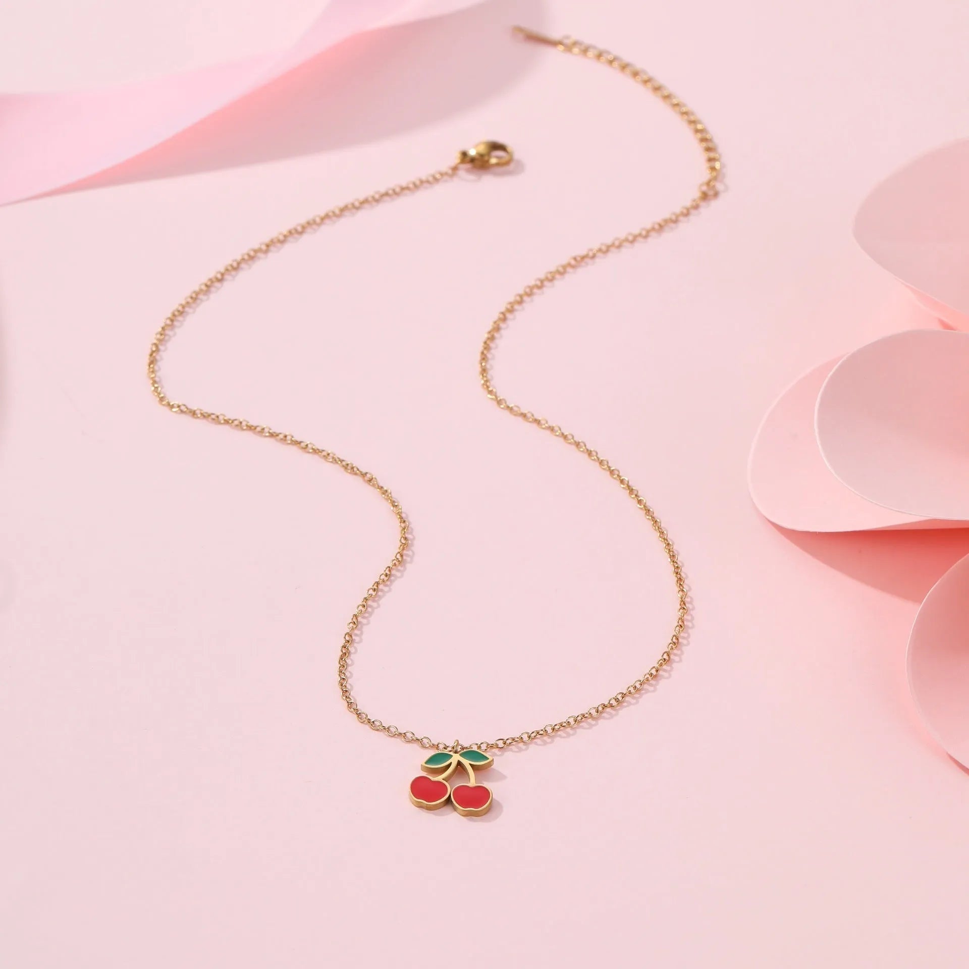 Stainless steel cherry jewellery set showing necklace, bracelet, earrings, and ring with geometric design.