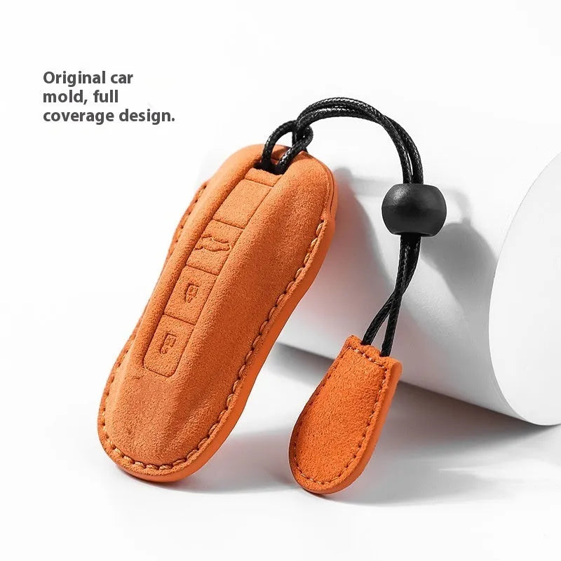 Suede car key cover in cement grey, dark green, light grey, and orange colour options