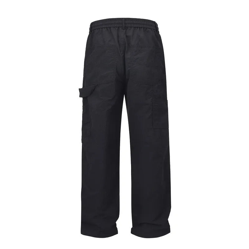 Black men's baggy paratrooper trousers with a drawstring elastic waistband on a plain background.