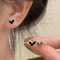 Three pairs of women's heart-shaped alloy earrings in gold, black, pink and black-white colours