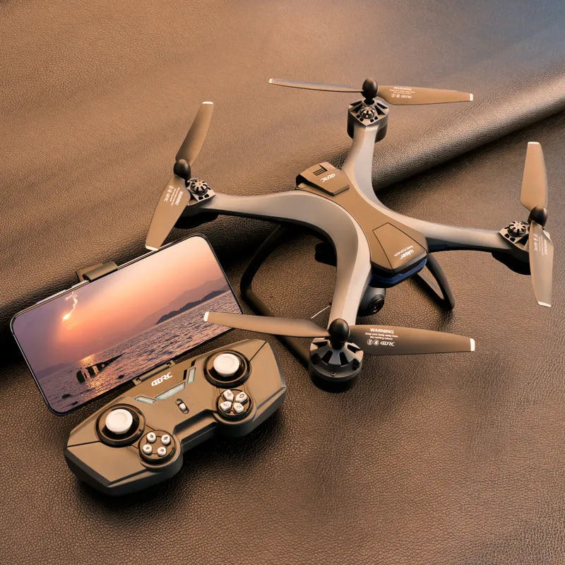 Plastic quadrocopter drone with four propellers, a remote controller, and included spare parts laid out.