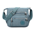 Grey nylon messenger bag with single shoulder strap showing square vertical shape and lining interior