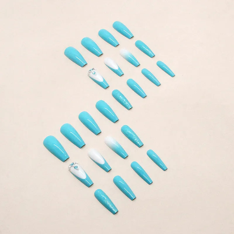 Solid blue long ballet shaped false nail art patches with a bottle of adhesive glue on a white background.