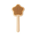 Green self-cleaning cat comb with stainless steel pins on a white background