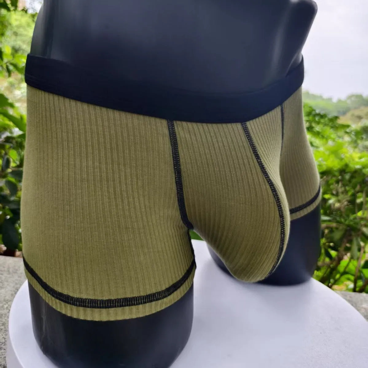 Men's solid colour boxer shorts in breathable fibre fabric on a plain background.