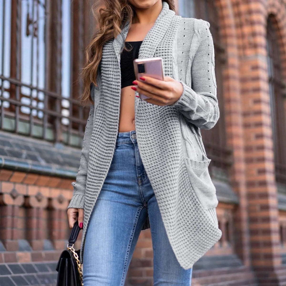 Grey loose-fit women's cardigan sweater coat with pockets, shown on a hanger.