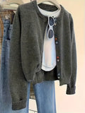 Dark grey women's button-front cardigan sweater with long sleeves on a hanger.