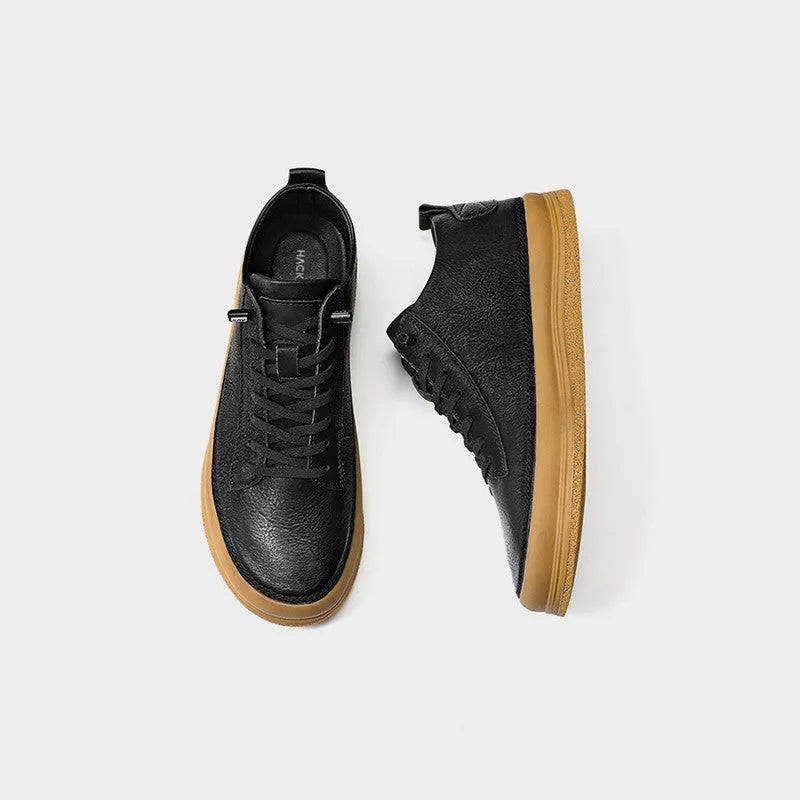Men's black leather casual shoes with round toe, flat heel, and white rubber sole on a plain background.