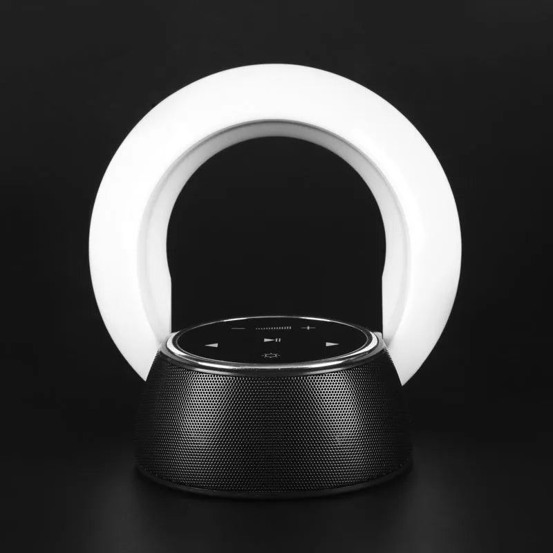 Foldable blue and white Bluetooth desk lamp with speaker, showing touch controls on a desk.