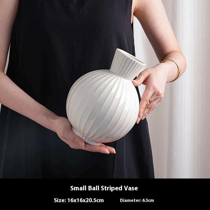 White ceramic ball striped vase in American country style on table with orchid arrangement