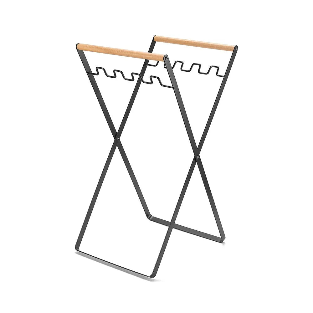 Black folding iron outdoor trash rack with a wooden handle holding a waste bag.