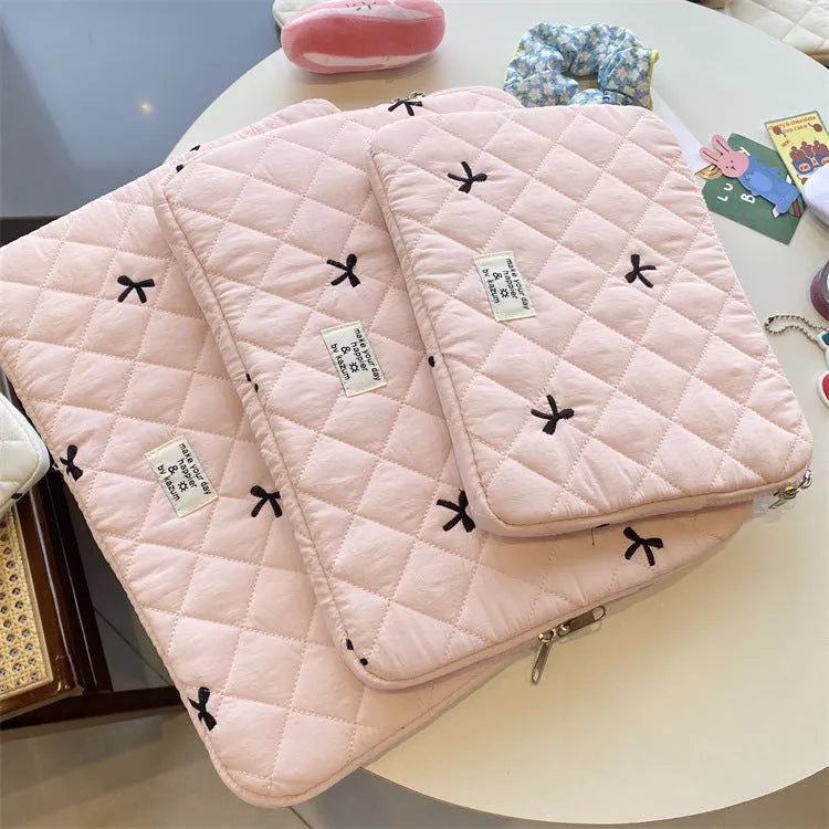Nylon laptop storage bag with a rhombus-shaped embroidered bow on the front.