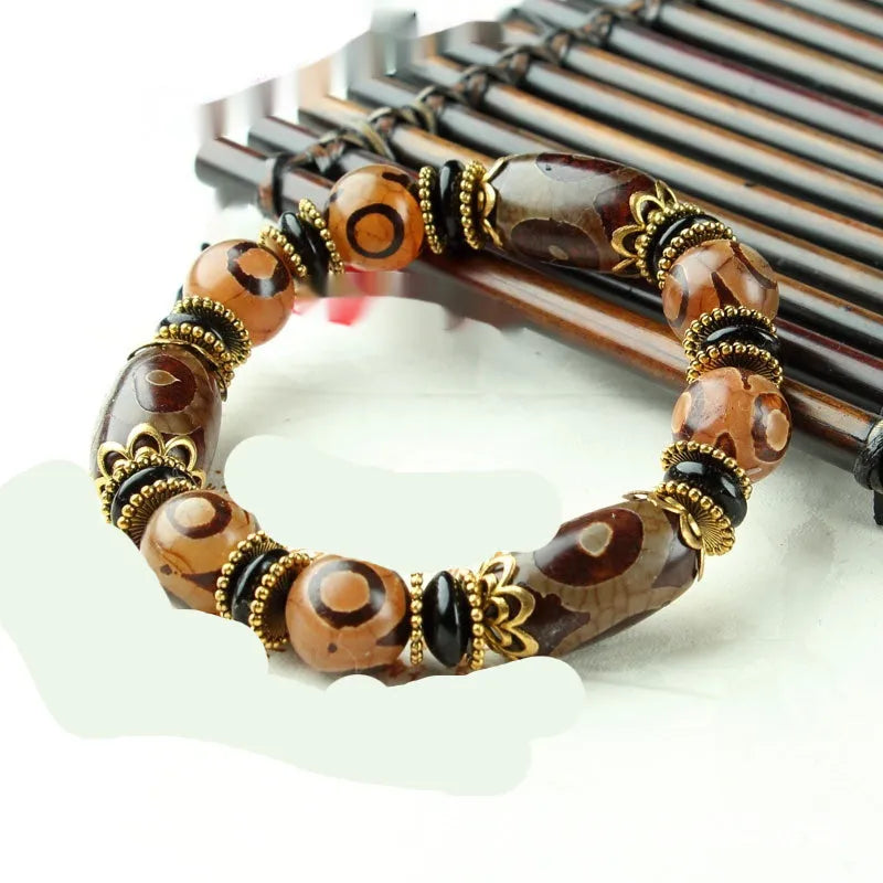 Distressed agate bracelet with traditional Tibetan dzi beads including three-eye and Nine Eyes designs.