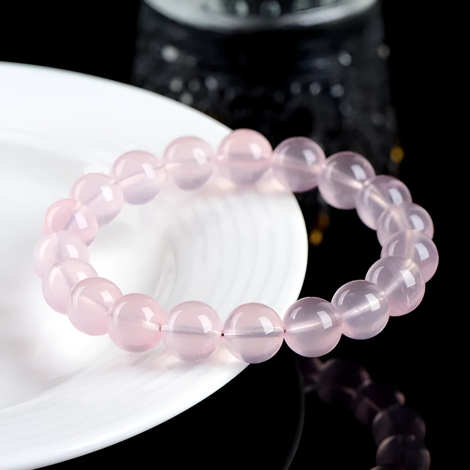 A pink crystal bead bracelet with polished round stones on a single strand.