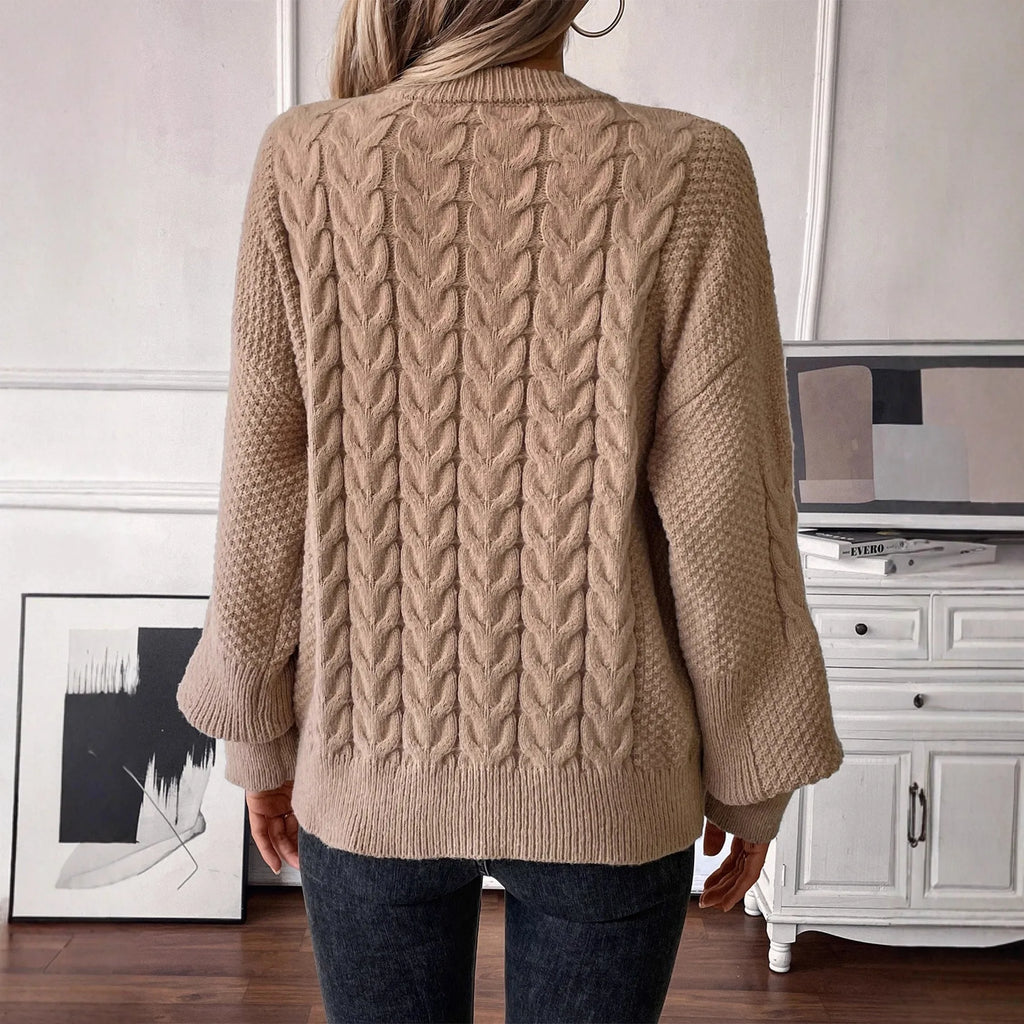 Women's beige loose-fitting sweater with twisted detailing on a hanger.